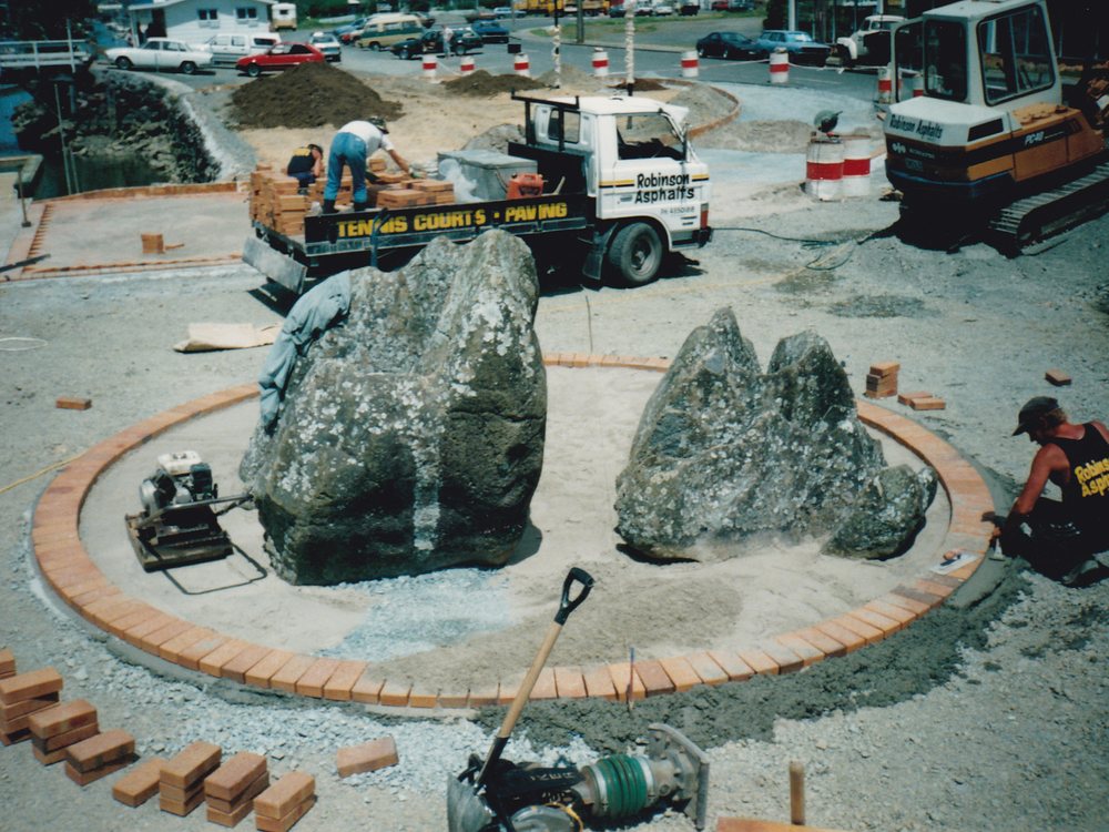 Boulders set in a brick-edged garden with a Robinson Asphalts truck and digger behind
