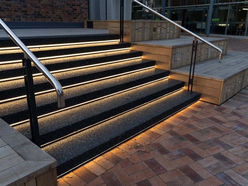 Lit stairs and timber tiered seating at a civic centre forecourt, Whangārei