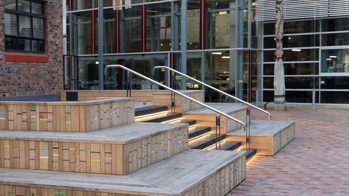 Timber tiered seating and lit steps at a civic centre forecourt, Whangārei