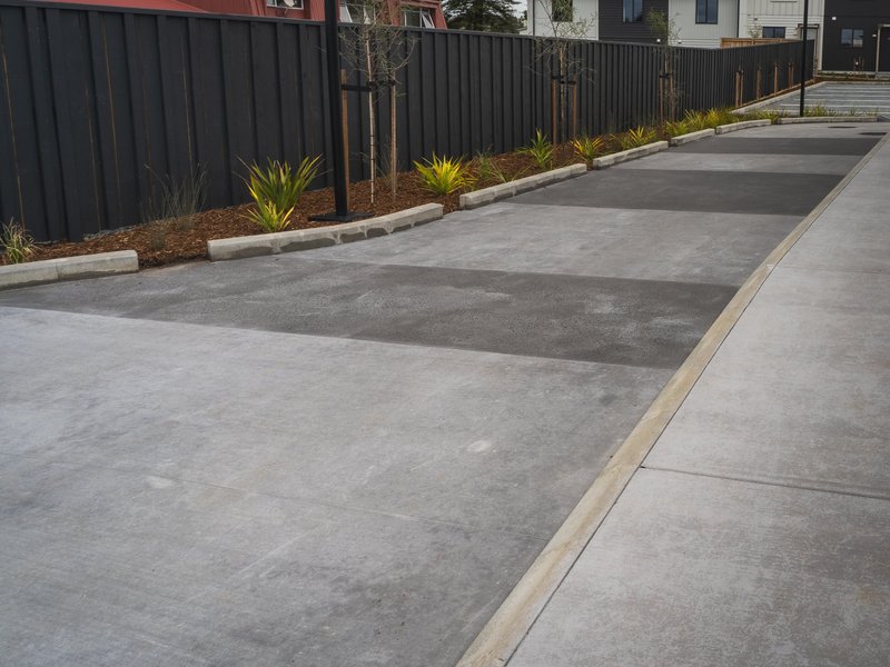 Concrete driveway with darker bands, kerbing and fresh planting