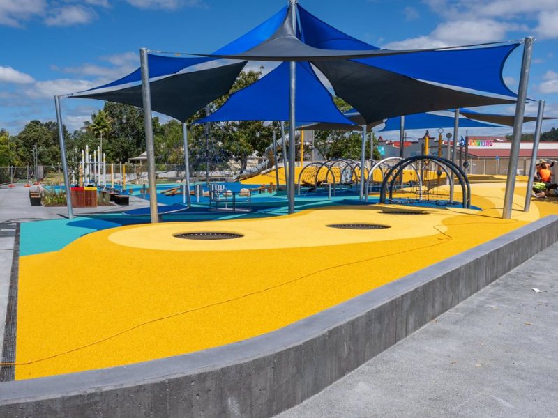 Town Basin Playground with shade sails and coloured safety surfacing