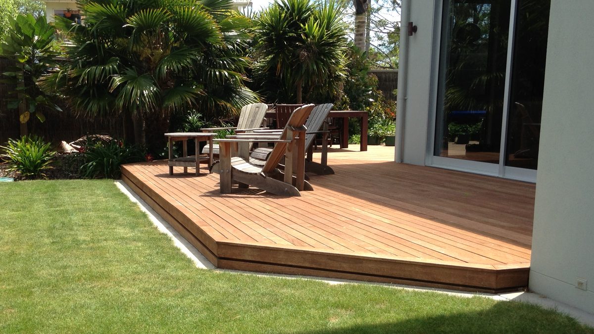 Hardwood deck beside a lawn and palm garden