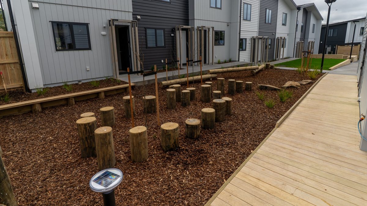 Nature play space with timber posts and logs beside new homes
