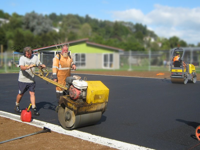 Robinsons crew rolling new asphalt for a school court