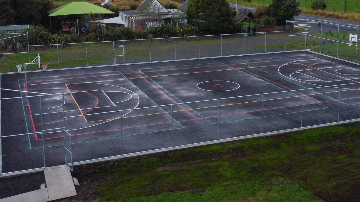 Fenced multi-sport asphalt court with basketball hoops