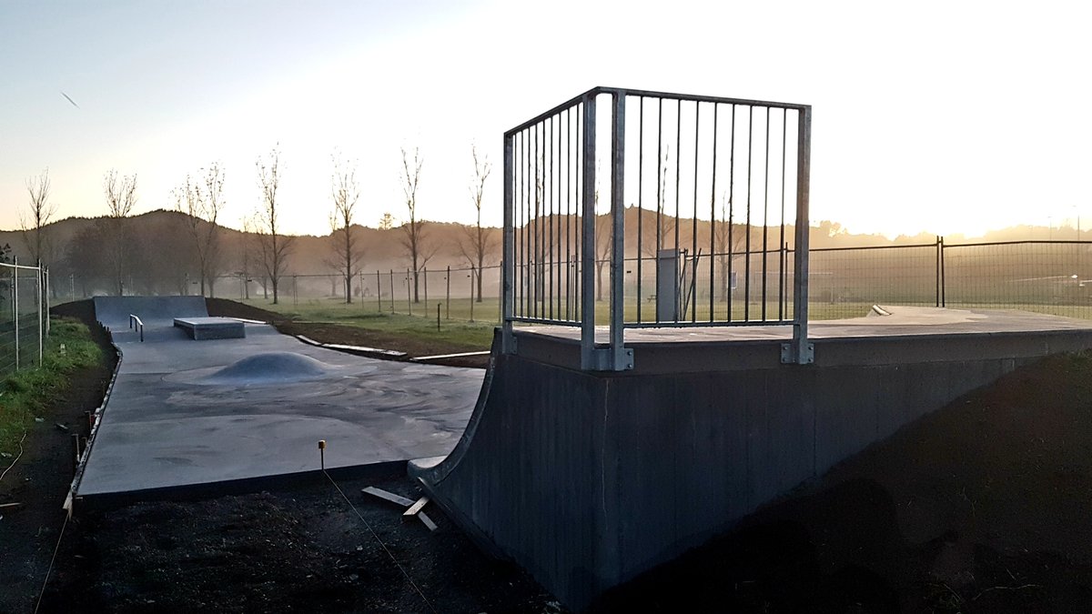 Concrete skatepark with ramp, rail and box