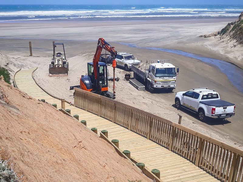 Robinsons crew and trucks building the Baylys Beach boardwalk on the dunes